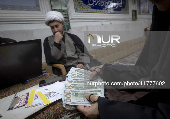 A veiled Iranian woman checks donated U.S. dollar banknotes during a charity ceremony to help the Lebanese Resistance Front and its affected...