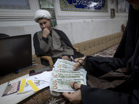 A veiled Iranian woman checks donated U.S. dollar banknotes during a charity ceremony to help the Lebanese Resistance Front and its affected...