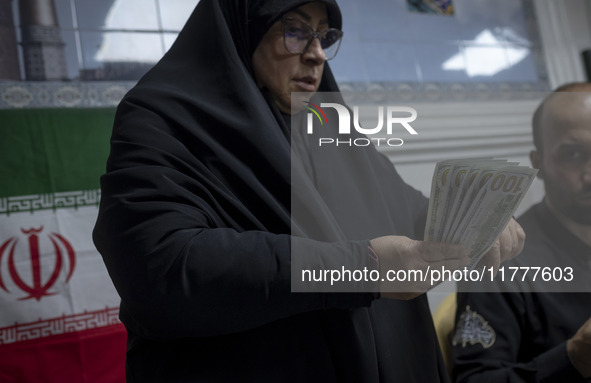 A veiled Iranian woman holds donated U.S. dollar banknotes during a charity ceremony to help the Lebanese Resistance Front and its affected...