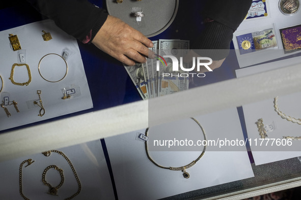 A veiled Iranian woman adjusts U.S. dollar banknotes donated during a charity ceremony by other veiled women to help the Lebanese Resistance...