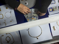 A veiled Iranian woman adjusts U.S. dollar banknotes donated during a charity ceremony by other veiled women to help the Lebanese Resistance...