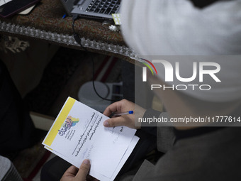 An Iranian cleric holds a signed document with Persian script that reads, ''I donate my gold with the intention of helping the war-torn peop...