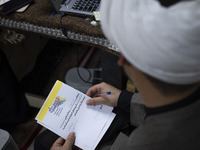 An Iranian cleric holds a signed document with Persian script that reads, ''I donate my gold with the intention of helping the war-torn peop...