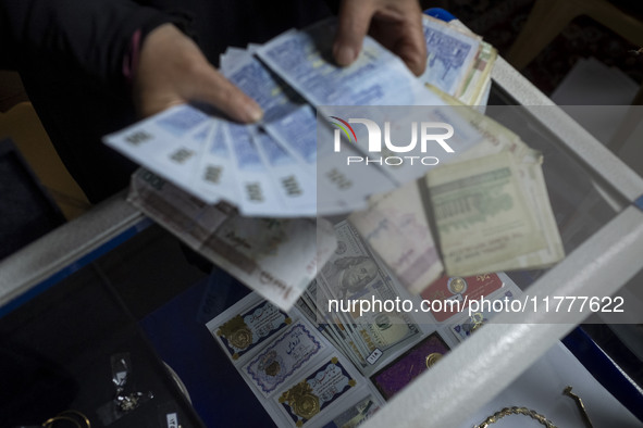 A veiled Iranian woman checks donated Iranian banknotes, while donated U.S. dollar banknotes are pictured during a charity ceremony to help...