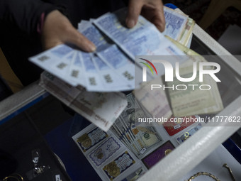 A veiled Iranian woman checks donated Iranian banknotes, while donated U.S. dollar banknotes are pictured during a charity ceremony to help...