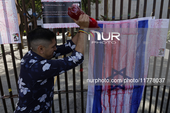 A pro-Palestine activist in Mexico City, Mexico, paints an Israeli flag outside the Memory and Tolerance Museum, where more people demand th...