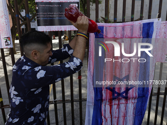 A pro-Palestine activist in Mexico City, Mexico, paints an Israeli flag outside the Memory and Tolerance Museum, where more people demand th...