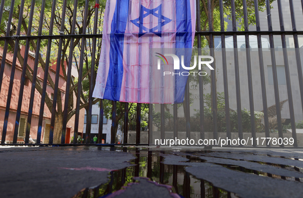 A pro-Palestine activist paints an Israeli flag in Mexico City, Mexico, outside the Museo Memoria y Tolerancia, where people demand that Cla...