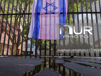 A pro-Palestine activist paints an Israeli flag in Mexico City, Mexico, outside the Museo Memoria y Tolerancia, where people demand that Cla...