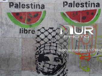 A pro-Palestine activist in Mexico City, Mexico, paints graffiti outside the Memory and Tolerance Museum, where more people demand Claudia S...