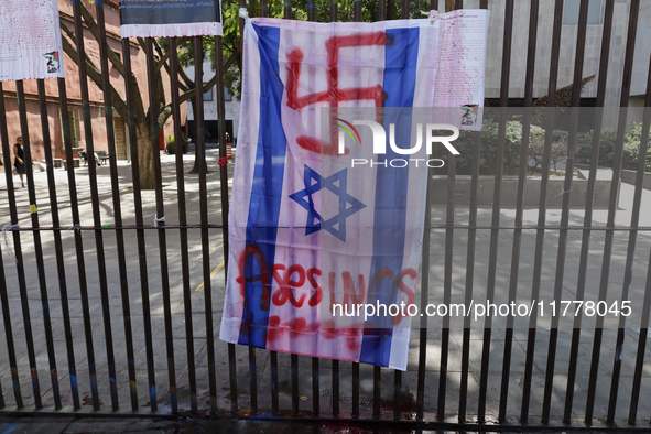 A pro-Palestine activist paints an Israeli flag in Mexico City, Mexico, outside the Museo Memoria y Tolerancia, where people demand that Cla...