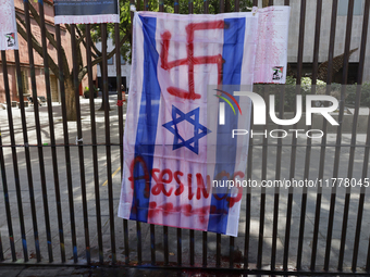 A pro-Palestine activist paints an Israeli flag in Mexico City, Mexico, outside the Museo Memoria y Tolerancia, where people demand that Cla...