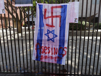 A pro-Palestine activist paints an Israeli flag in Mexico City, Mexico, outside the Museo Memoria y Tolerancia, where people demand that Cla...