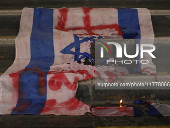 A pro-Palestine activist burns an Israeli flag in Mexico City, Mexico, outside the Ministry of Foreign Affairs, where more people demand tha...