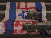 A pro-Palestine activist burns an Israeli flag in Mexico City, Mexico, outside the Ministry of Foreign Affairs, where more people demand tha...