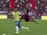 Jose Andres Martinez of Venezuela competes for the ball with Savinho of Brazil during a 2026 FIFA World Cup qualifier at the Monumental stad...