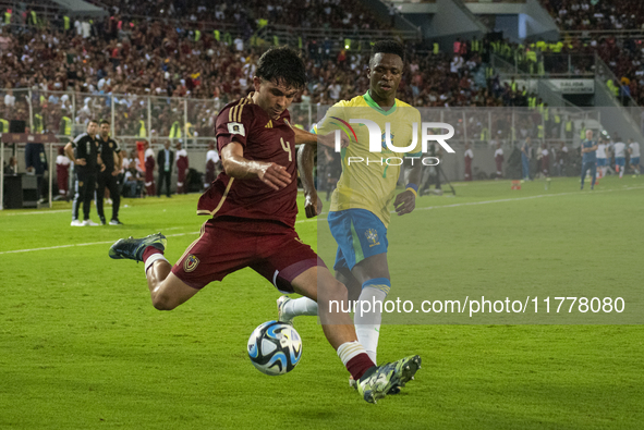 Jon Aramburu of Venezuela fights for the ball with a player from Brazil during a 2026 FIFA World Cup qualifier at the Monumental stadium in...