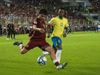 Jon Aramburu of Venezuela fights for the ball with a player from Brazil during a 2026 FIFA World Cup qualifier at the Monumental stadium in...