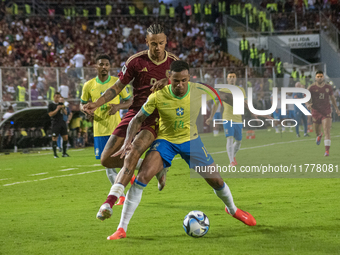 Eric Ramirez of Venezuela competes for the ball with a player from Brazil during a 2026 FIFA World Cup qualifier at the Monumental stadium i...