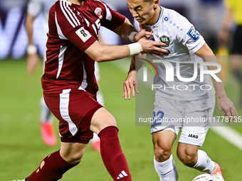 Bassam Alrawi (#15) of Qatar battles for the ball with Abbosbek Fayazullaev (#22) of Uzbekistan during the FIFA World Cup 2026 AFC Asian Qua...