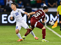 Bassam Alrawi of Qatar battles for the ball with Abbosbek Fayazullaev of Uzbekistan during the FIFA World Cup 2026 AFC Asian Qualifiers thir...