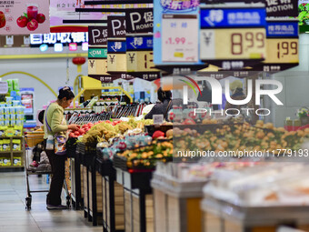 Consumers shop at a supermarket in Qingzhou, China, on November 15, 2024. On November 15, 2024, the National Bureau of Statistics releases d...