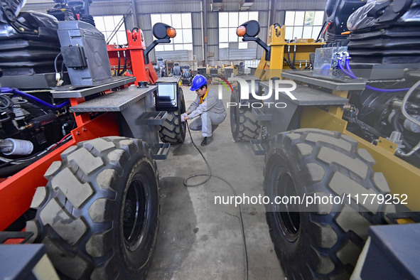 A worker works at a loader manufacturing enterprise in Qingzhou Economic Development Zone, East China's Shandong province, on November 15, 2...