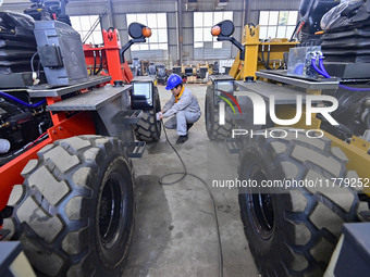 A worker works at a loader manufacturing enterprise in Qingzhou Economic Development Zone, East China's Shandong province, on November 15, 2...