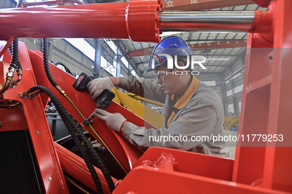 A worker works at a loader manufacturing enterprise in Qingzhou Economic Development Zone, East China's Shandong province, on November 15, 2...