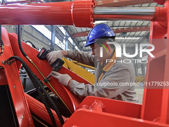 A worker works at a loader manufacturing enterprise in Qingzhou Economic Development Zone, East China's Shandong province, on November 15, 2...