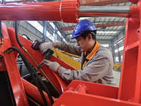 A worker works at a loader manufacturing enterprise in Qingzhou Economic Development Zone, East China's Shandong province, on November 15, 2...