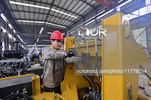 A worker works at a loader manufacturing enterprise in Qingzhou Economic Development Zone, East China's Shandong province, on November 15, 2...