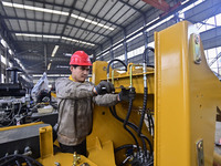 A worker works at a loader manufacturing enterprise in Qingzhou Economic Development Zone, East China's Shandong province, on November 15, 2...