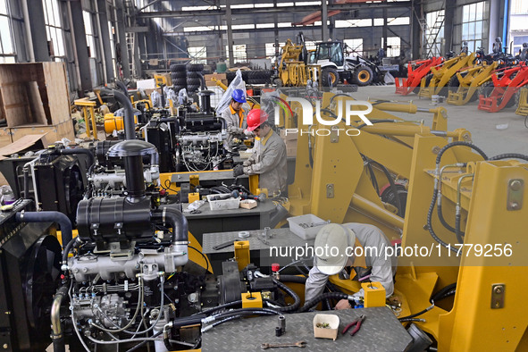 A worker works at a loader manufacturing enterprise in Qingzhou Economic Development Zone, East China's Shandong province, on November 15, 2...