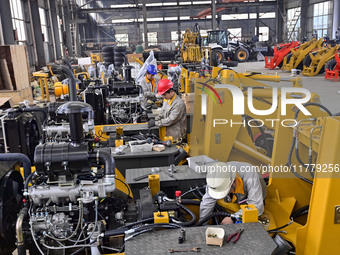 A worker works at a loader manufacturing enterprise in Qingzhou Economic Development Zone, East China's Shandong province, on November 15, 2...