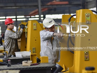 A worker works at a loader manufacturing enterprise in Qingzhou Economic Development Zone, East China's Shandong province, on November 15, 2...