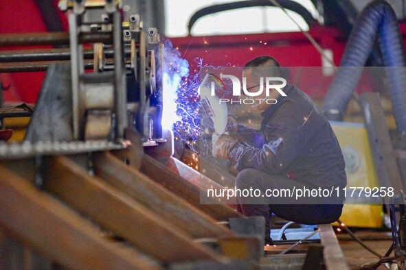 A worker works at a loader manufacturing enterprise in Qingzhou Economic Development Zone, East China's Shandong province, on November 15, 2...