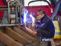 A worker works at a loader manufacturing enterprise in Qingzhou Economic Development Zone, East China's Shandong province, on November 15, 2...