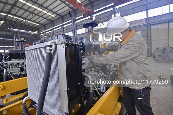 A worker works at a loader manufacturing enterprise in Qingzhou Economic Development Zone, East China's Shandong province, on November 15, 2...