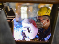 A worker works at a loader manufacturing enterprise in Qingzhou Economic Development Zone, East China's Shandong province, on November 15, 2...