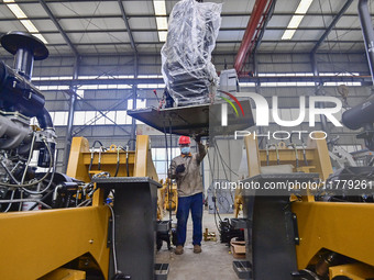 A worker works at a loader manufacturing enterprise in Qingzhou Economic Development Zone, East China's Shandong province, on November 15, 2...