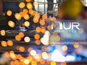 A worker works at a loader manufacturing enterprise in Qingzhou Economic Development Zone, East China's Shandong province, on November 15, 2...