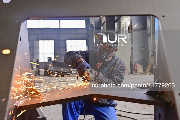 A worker works at a loader manufacturing enterprise in Qingzhou Economic Development Zone, East China's Shandong province, on November 15, 2...