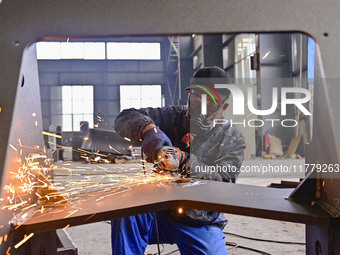 A worker works at a loader manufacturing enterprise in Qingzhou Economic Development Zone, East China's Shandong province, on November 15, 2...