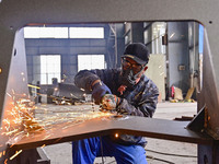 A worker works at a loader manufacturing enterprise in Qingzhou Economic Development Zone, East China's Shandong province, on November 15, 2...