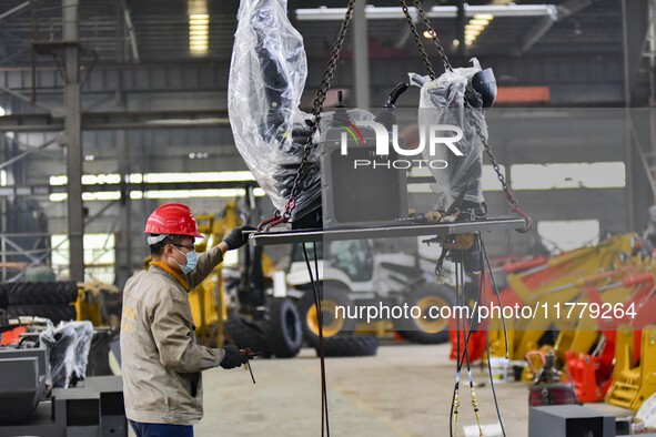 A worker works at a loader manufacturing enterprise in Qingzhou Economic Development Zone, East China's Shandong province, on November 15, 2...