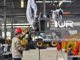 A worker works at a loader manufacturing enterprise in Qingzhou Economic Development Zone, East China's Shandong province, on November 15, 2...