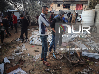 Palestinians inspect the site of an Israeli strike on tents of displaced people in Deir Al-Balah, Gaza Strip, on November 15, 2024. (