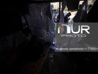 Palestinians inspect the site of an Israeli strike on tents of displaced people in Deir Al-Balah, Gaza Strip, on November 15, 2024. (