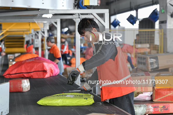 Workers work at the newly operational STO Express Hefei transit center in Hefei, China, on November 13, 2024. 